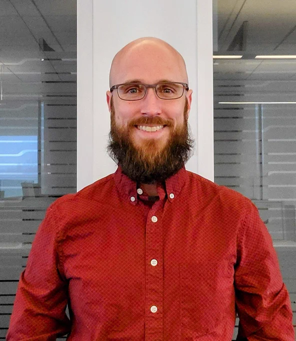 Man wearing red in office setting to raise awareness of women's heart disease