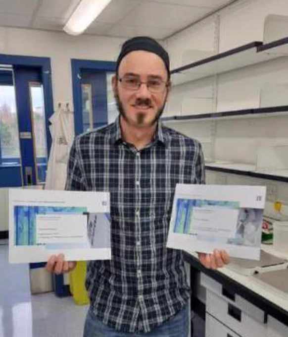 Tom Williams with award certificates
