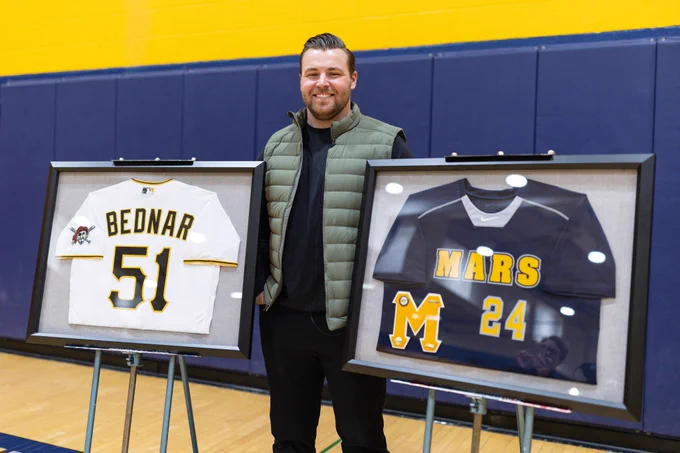 David Bednar poses with a framed Pirates Bednar jersey (#51) and a framed Mars jersey (#24) at his number retirement ceremony at Mars Area High School