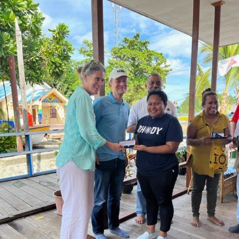 URI President Marc Parlange and Mary Parlange greet an alumni in Indonesia.