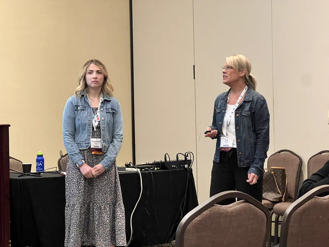 Kelly and Alyssa presenting in front of room at ATIA 2023