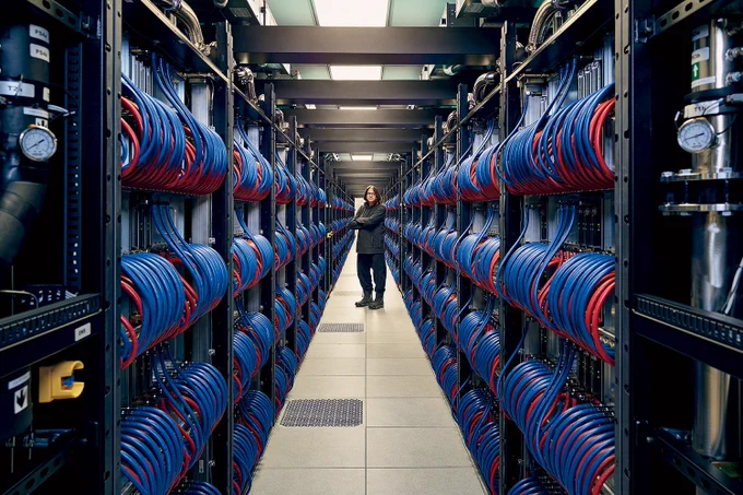 Argonne's Rick Stevens stands between racks of the lab's Aurora supercomputer.