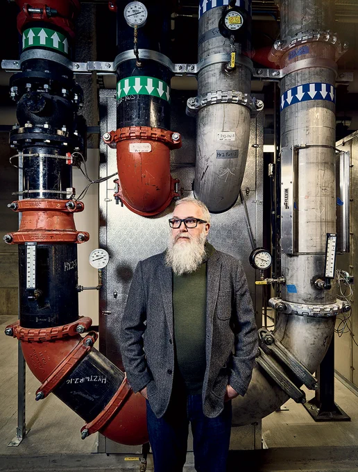 Argonne's Mike Papka stands in front of Aurora's water cooling infratructure.