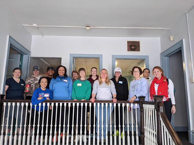 a group of JLB members posing in the stairwell at Compass House