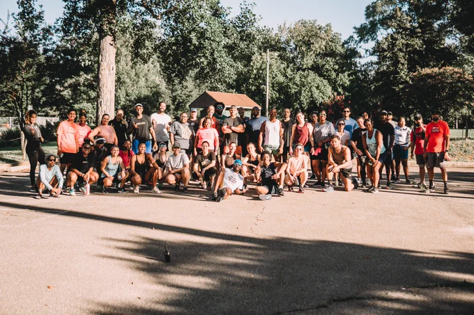 Members of #WeOffTheCouch taking a group photo surrounded by trees. 