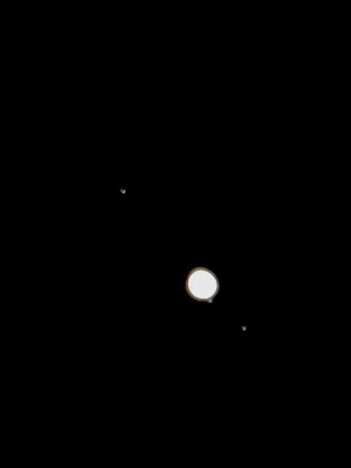 Jupiter, partially visible are 3 of its many moons
