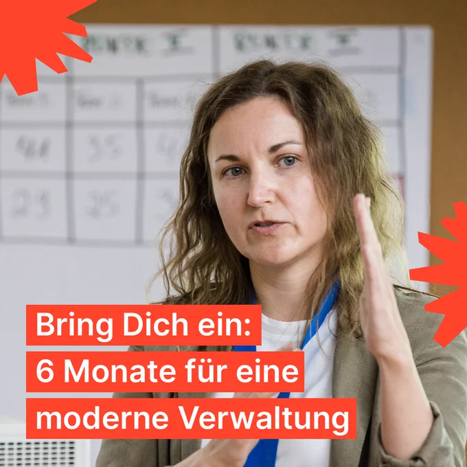 Eine Frau präsentiert und gestikuliert vor einer Pinnwand. Auf dem Foto ist auf orangenem Hintergrund der Schriftzug zu lesen: Bring Dich ein: 6 Monate für eine moderne Verwaltung. 