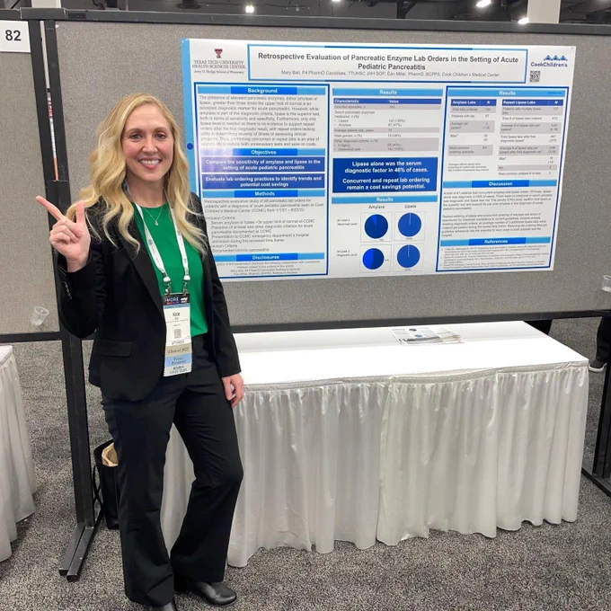 Female TTUHSC pharmacy student stands in front of her research poster at a conference.