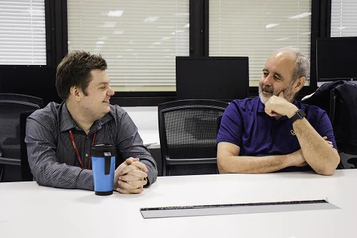 Vision Australia CEO Ron Hooton with client Grant having a discussion in an office setting