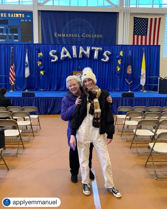 Grandmother and granddaughter in front of EV Saints balloon banner.
