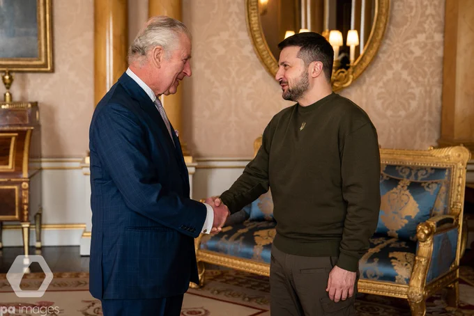 King Charles III (left, in a dark blue suit) holds an audience with Ukrainian President Volodymyr Zelensky (right, wearing a dark green top) at Buckingham Palace