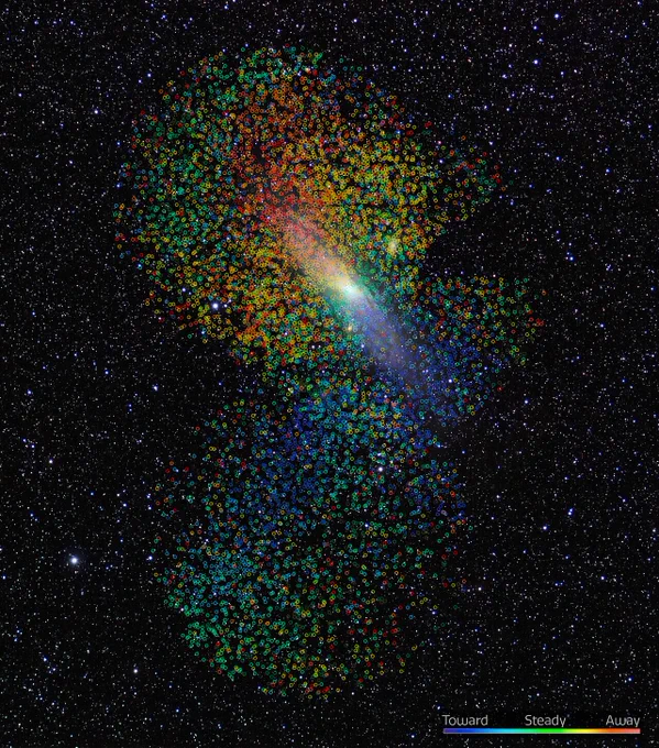 An image of the Andromeda Galaxy covered in multicolored dots, each of which represents the motion of an individual star in the Andromeda Galaxy.