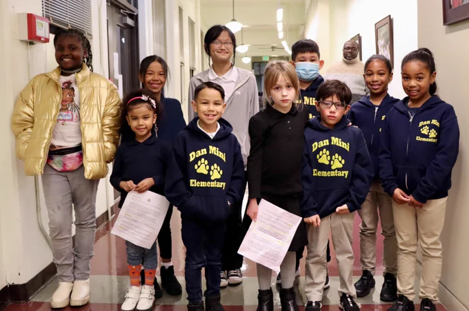 Group of students stands in two lines and poses as a group. 