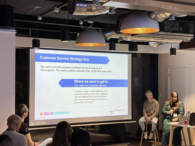 Laura Van Kristen & Surita Solanki presenting their talk, the slide shows their Customer service strategy aims
