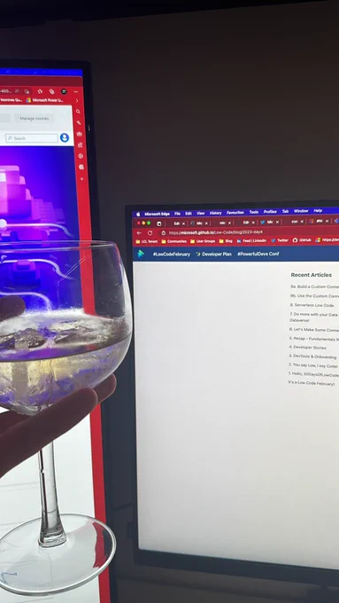 Lewis holding a gin glass with monitors in the background on the low code february sites