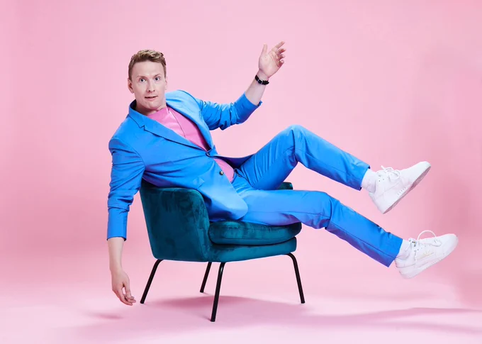 Joe Lycett sitting on a chair
