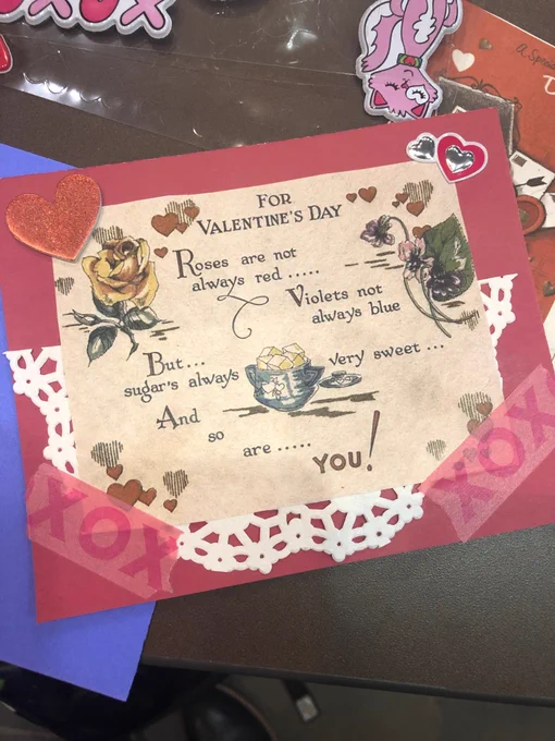 Handmade valentine made collaging vintage Valentine with stickers, decorative tape, and a doily. 