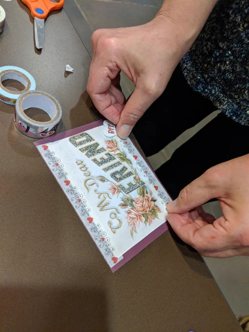 Close up of someone's hands adding decorative tape to a valentine