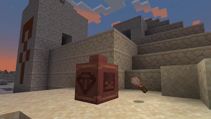 A pot and a brush in front of a desert temple