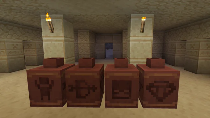 Four pots with various designs are placed in a row in a desert setting