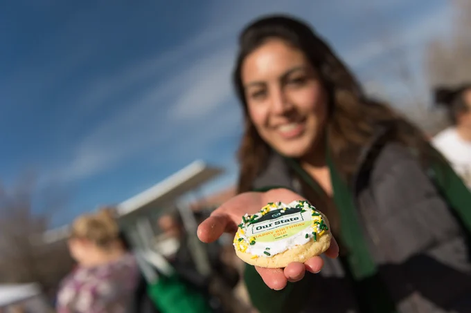 Student holding CSU birthday cookie