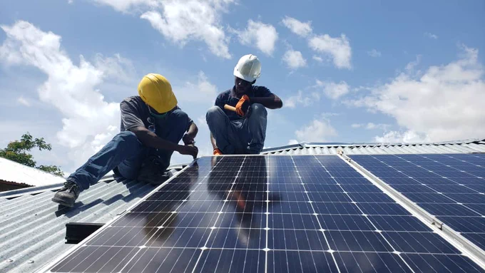 @enejipwop technicians install solar panels on the roof of a customer participating in a @SunspotPV electric cooking pilot program in rural Haiti.