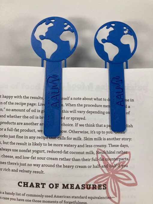 Two globe bookmarks clipped to a book page