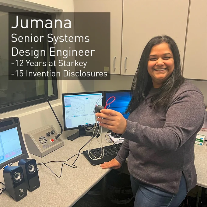 Jumaya, a Senior Sytems Design Engineer, smiles and holds up a hearing aid connected to testing equipment. She has been with Starkey for 12 years and has 15 invention disclosures.