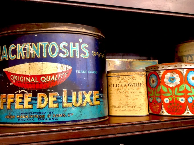 A display of vintage tins including Mackintosh’s Toffee Deluxe