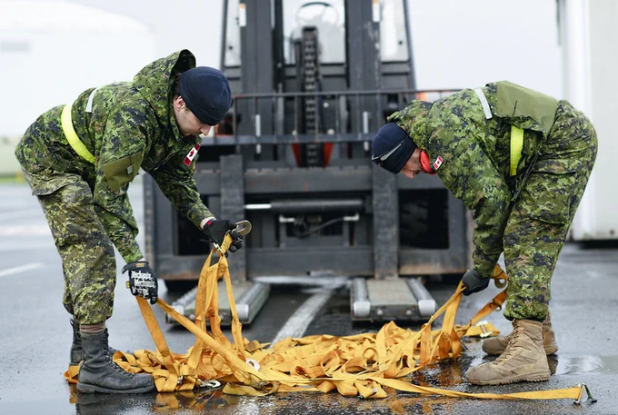 Le caporal Drake Tatlock (à gauche) et l’aviateur Dean Hammond (à droite), membres du 2e Escadron des mouvements aériens, préparent le filet de fret qui servira à arrimer la marchandise à bord d’un avion CC-177 Globemaster, dans le cadre du soutien offert à la Force opérationnelle Prestwick, le 31 janvier 2023, en Écosse, au Royaume-Uni.

 

Photo : Caporale chef Desiree Bourdon, Caméra de combat des Forces canadiennes