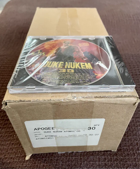 An unopened box filled with 30 Duke Nukem Atomic CDs with the Apogee label.  On top of the box is a Duke Nukem 3D CD in a Jewel Case, unopened. 