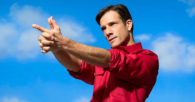 A photo showing Danny Mac pointing his fingers like a gun