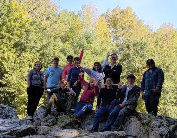 Yogev Laboratory at annual Retreat in Vermont (group pictures on a rock covered in moss with trees in the background).