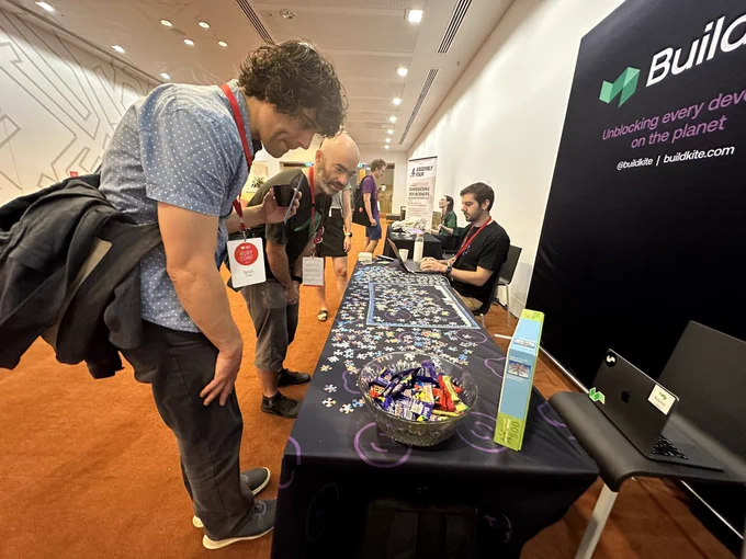 People checking out the Buildkite booth swag at RubyConf AU 2023.