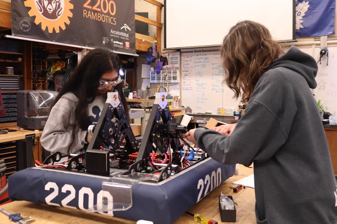 Two students assembling parts.