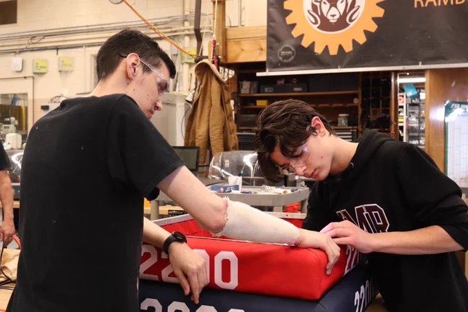 Student and mentor fixing bumpers for robot.