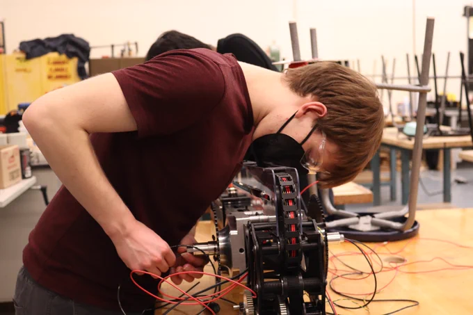 One student wiring a robot.