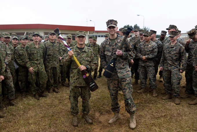 U.S. Marines with maritime raid force, 31st Marine Expeditionary Unit and members of the reconnaissance battalion, Amphibious Rapid Deployment Brigade, exchange paddles during the opening ceremony of their subject matter expert exchange for Iron Fist 23 on Camp Hansen, Okinawa, Japan, Feb. 14, 2023. The USMC and ARDB regularly come together for training evolutions and celebrate a long-standing history of cooperation and partnership. Iron Fist is an annual bilateral exercise designed to increase interoperability and strengthen the relationships between the U.S. Marine Corps, the U.S. Navy, the Japan Ground Self-Defense Force, and the Japan Maritime Self-Defense Force. (U.S. Marine Corps Photo by Cpl. Christopher W. England)

