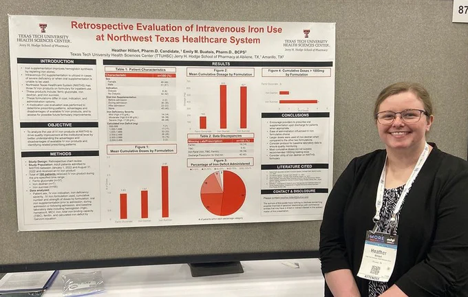 Female TTUHSC pharmacy student stands in front of her research poster at a conference.