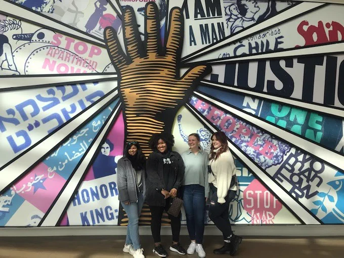 A group of students stands in front of a mural at the National Center for Civil and Human Rights.