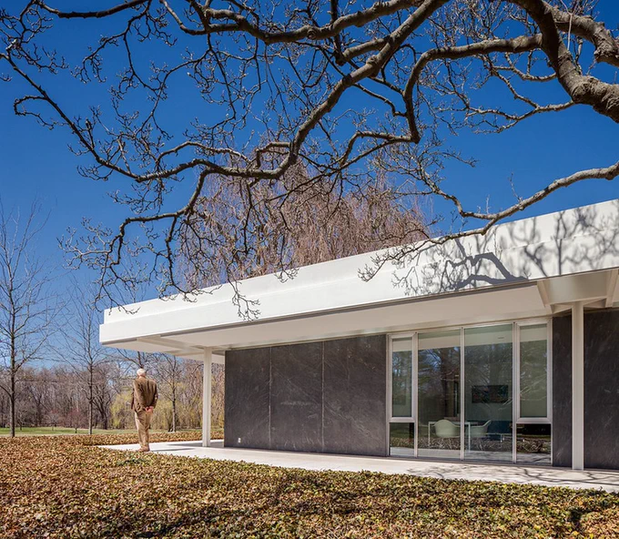 exterior photo of modern home with man standing with back to camera