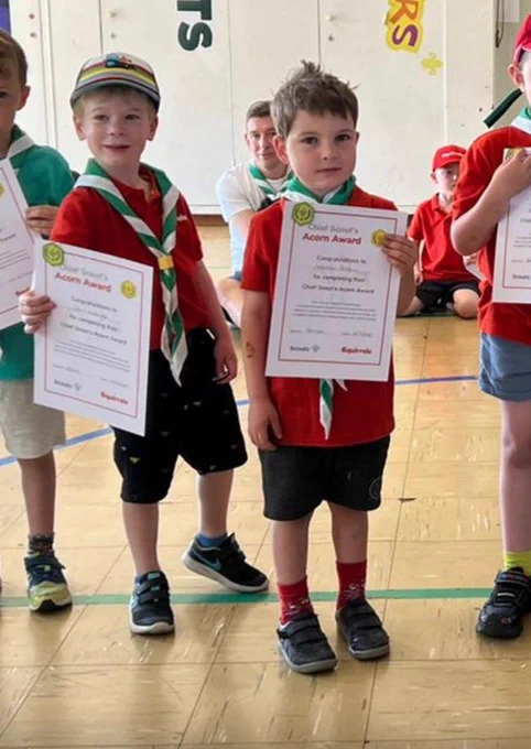 Squirrel Scouts holding Acorn Award Certificates