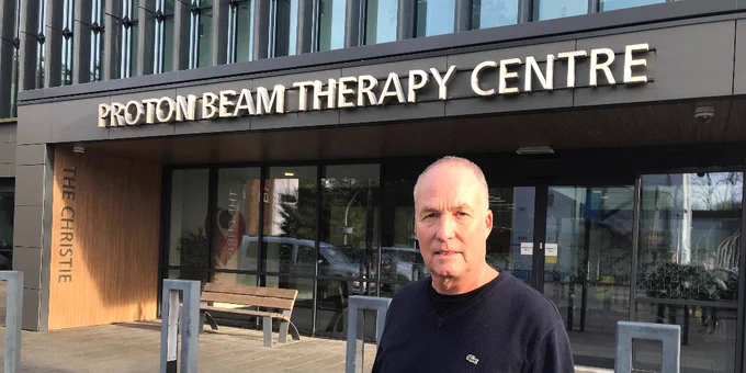 1000th proton beam therapy patient at The Christie, Adrian Bishop, standing outside the Christie proton beam therapy centre