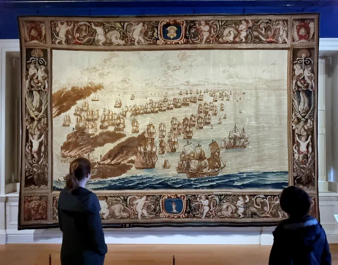 Photo of two people standing in front of the Solebay Tapestry