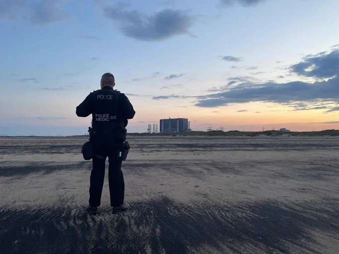 A CNC police medic AFO stands overlooking Hartlepool site at sunset. 