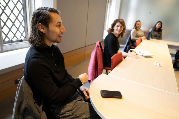 Political science Ph.D. student Miguel Martinez discusses his experience as a peer mentor while Maria Wisdom, director of the peer mentoring program, listens.