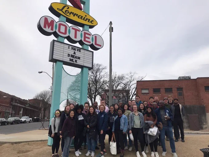 A group of students and staff stand in front of a sign that reads "Lorraine Motel I Have a Dream MLK"