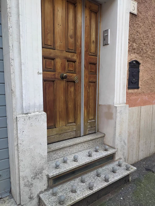 Door step with large round balls attached to the steps to prevent anyone from sitting