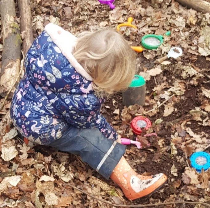 Child playing with magnifying glasses in leaves (c) Mandi Rankine