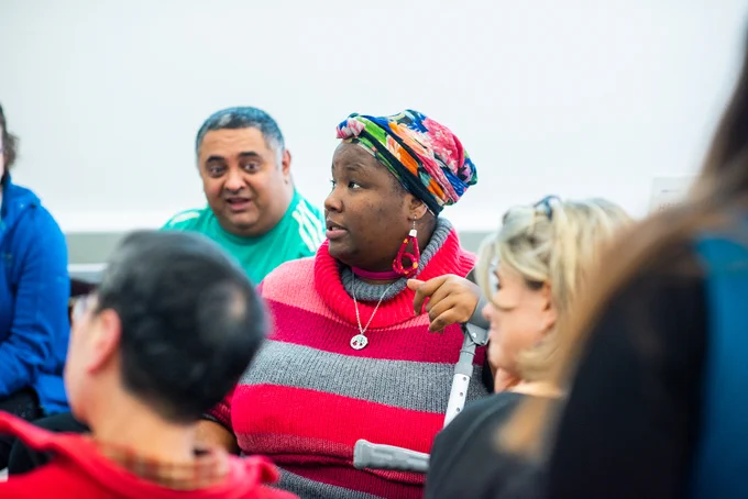 A woman participating in a group discussion with public partners and researchers.
